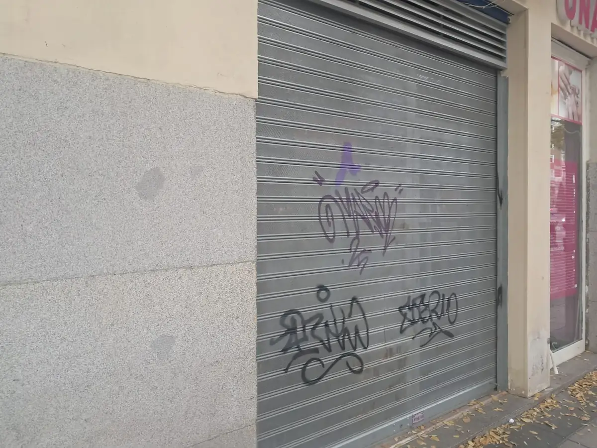 Persiana metàl·lica microperforada abaixada davant d’un comerç de Barcelona